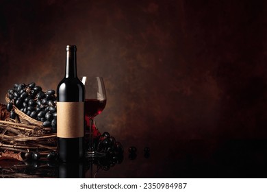 Glass and bottle of red wine with blue grapes on a black reflective background. On a bottle old empty label. Copy space. - Powered by Shutterstock