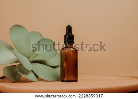 Glass bottle for a serum on beige empty background