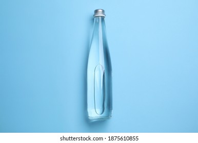 Glass Bottle With Water On Light Blue Background, Top View