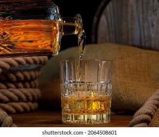 Glass and bottle of whiskey on rustic background
