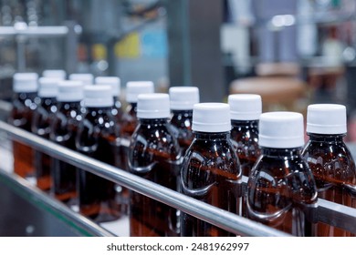 glass bottle with white cap moving on conveyor belt of auto capping and labeling machine at energy drink beverage manufacturing. pharmaceutical or beverage industry. automation technology machinery. - Powered by Shutterstock