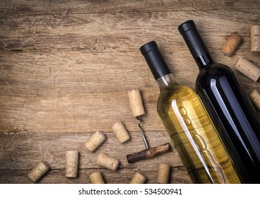 Glass bottle of wine with corks on wooden table background - Shutterstock ID 534500941