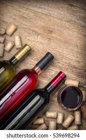 Glass Bottle Of Wine With Corks On Wooden Table Background