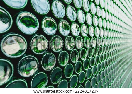 Glass bottles green. Green glass bottles of beer. Wall formed by green bottles. Green bottles background. Empty Glass Bottle with Lighting