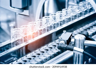 Glass bottles in production in the tray of an automatic liquid dispenser; a line for filling medicines against bacteria and viruses; antibiotics and vaccines. - Shutterstock ID 2094914938