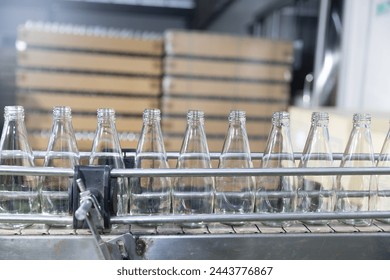 Glass bottles of purified drinking water inside drinking water or beverage factory which has automated conveyor production line. Water manufacture business. Beverages industry business. - Powered by Shutterstock