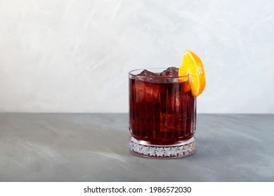 Glass Of Boulevardier Cocktail With Big Ice Cubes And Orange Slice. Classic Alcoholic Drink Composed Of Whiskey, Sweet Vermouth, And Campari.