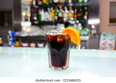 Glass Of Boulevardier Cocktail With Big Ice Cubes And Orange Slice. Classic Alcoholic Drink Composed Of Whiskey, Sweet Vermouth, And Campari.