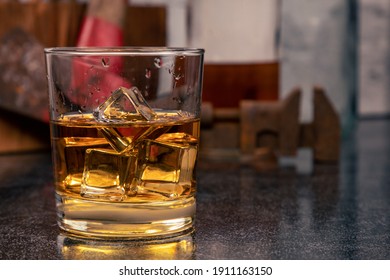 Glass Of Bourbon Whiskey, On The Rocks, With Ice, In Front Of Vintage Tools