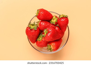 Glass bowl with fresh strawberries on orange background - Powered by Shutterstock