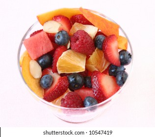 Glass bowl of fruit salad on a white linen tablecloth