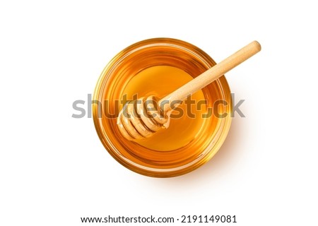 Glass bowl of honey with honey dipper isolated on white background. top view
