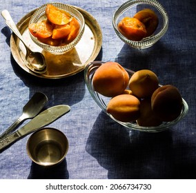 Glass Bowl With Peach Slices Placed On Top Of Silver Plate And Whole Peach Fruits Decorated On Light Blue Background.Overhead  View,closeup Of Fruits Platter,dark And Moody.
