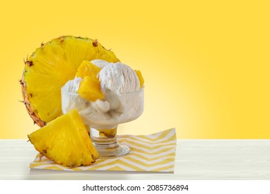 Glass bowl with pineapple ice cream balls. Yellow pineapple slices, tropical fruit. Cooling summer dessert.  - Powered by Shutterstock