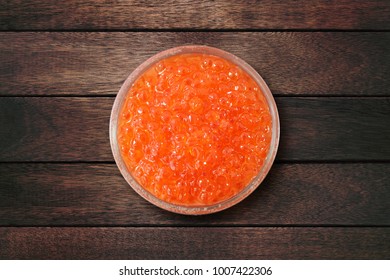 Glass Bowl With Red Salmon Caviar On Wooden Background. View From Above. Popular Souvenir From Russia.