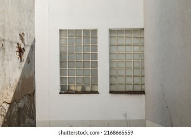 Glass Brick Windows In A White Stone Wall, Cracked Wall With Shadow On It, No Person, Space For Text, 