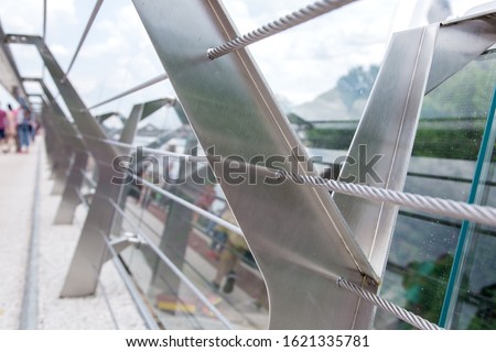 glass bridge with tension steel cables and steel railing supports.