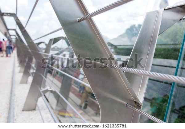 glass bridge with tension steel cables and\
steel railing supports.