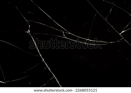 glass broken into a large number of pieces and cracks, a piece of glass with a large number of cracks and broken parts