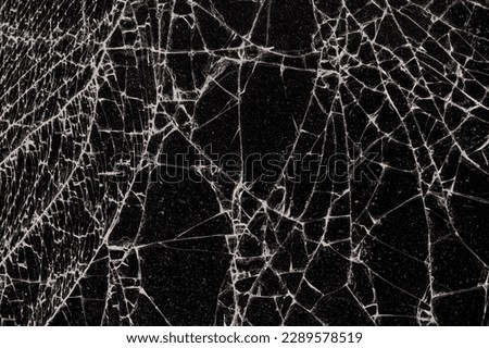 glass broken into a large number of pieces and cracks, a piece of glass with a large number of cracks and broken parts