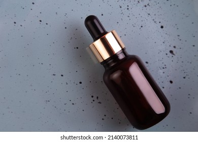 Glass Brown Bottle With Pipette With Essential Oil On Grey Background  Top View. Aromatic Cosmetic Product For Skin And Hair Care Moisturizing Beauty Product With Organic. Flatlay