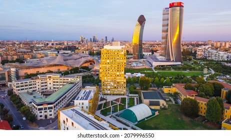 Glass Buildings In Europe City Life. Aerial View Of Modern Architecture Of Office Buildings In New City Districts. Night City Lights. The Drone Shoots At Three Towers. Milan, Italy, November 2021: 