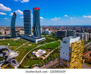 Glass Buildings In Europe City Life. Aerial View Of Modern Architecture Of Office Buildings In New City Districts. Night City Lights. The Drone Shoots At Three Towers. Milan, Italy, September 2022