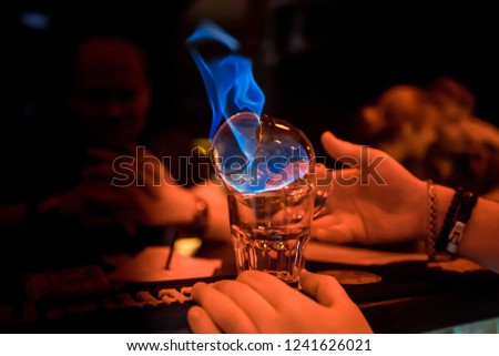 Glass with burning alcohol. Image of two glasses of burning emerald absinthe. Glass of tequila and flames