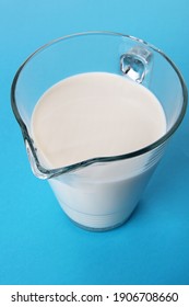 Carafe en verre contenant du lait frais isolée sur fond bleu à l'ombre. vue haute angle