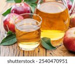 Glass and carafe of fresh apple juice and organic apples on old wooden table close up.