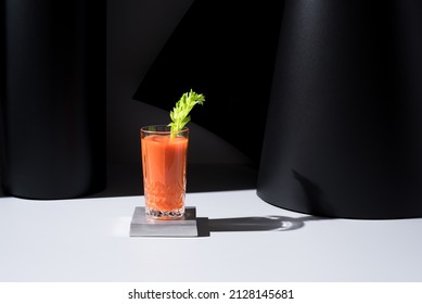 Glass Of Carrot Juice With Celery Leaf On Black Background