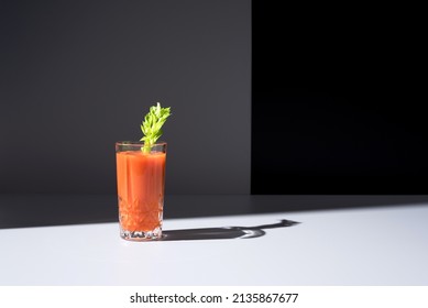 Glass Of Carrot Juice With Celery Leaf On Black Background