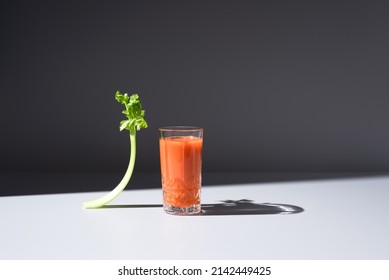 Glass Of Carrot Juice With Celery Leaf On Black Background