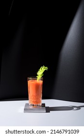 Glass Of Carrot Juice With Celery Leaf On Black Background