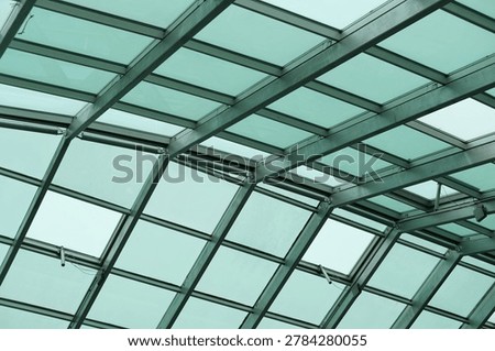 Glass ceiling grid with steel framework highlights architecture and structure, panels and daylight across the atmosphere