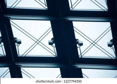 Glass ceiling with metal framework. Structural glazing. Toughened glass as modern architecture material. Close-up of office building fragment. Abstract architectural background.