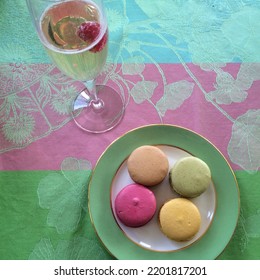 Glass Of Champagne And French Laduree Macarons In A Green White Plate