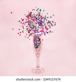 A Glass Of Champagne On A Pink Background With Confetti