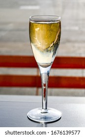 Glass Of Champagne On A Table In An Airport Business Lounge Isolated Against A Burred Backgoround