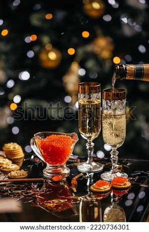 glass of champagne with red caviar appetizer cracker, butter and red caviar. Festive drink. Valentins or Christmas concept.