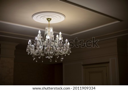 Glass chandelier. Ceiling light source. Lamps shine through a vintage chandelier.