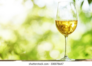 Glass of Chardonnay, Sauvignon or Rkatsiteli white wine over outdoors background 