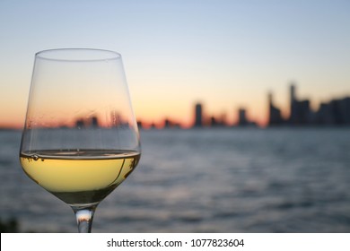 Glass of Chardonnay White Wine Overlooking the City of Miami Skyline Blurred After Dusk at Twilight in Key Biscayne, Florida