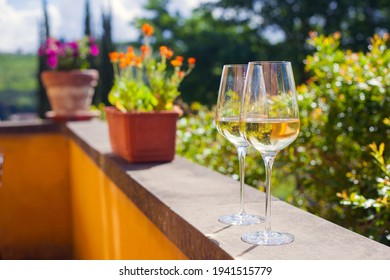 glass of chilled white wine on table over Tuscany backgound