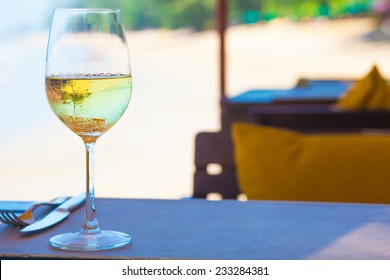 Glass Of Chilled White Wine On Table Near The Beach