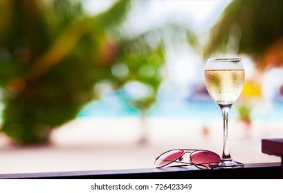 Glass Of Chilled White Wine On Table Near The Beach