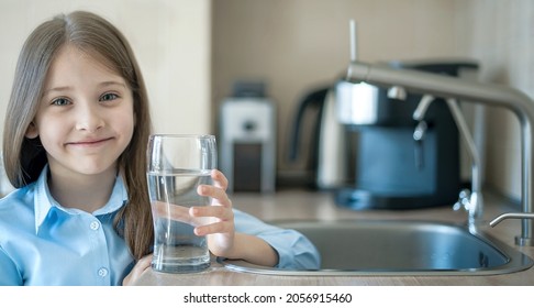 A Glass Of Clean Water In Kids Hands. Caucasian Little Girl Drinking From Water Tap Or Faucet In Kitchen. Pouring Fresh Healthy Drink. Good Habit. Right Choice. Environment Concept. World Water Day