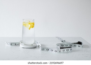 A Glass Of Clean Water With Lemon Slices. Nearby Is Centimeter. Healthy Food Concept. Losing Weight Concept.