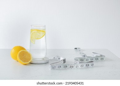 A Glass Of Clean Water With Lemon Slices, Next To A Fresh Lemon And A Centimeter. Healthy Food Concept. Losing Weight Concept.