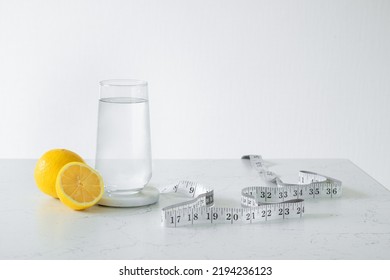 A Glass Of Clean Water Next To A Fresh Lemon And A Centimeter. Healthy Food Concept. Losing Weight Concept.